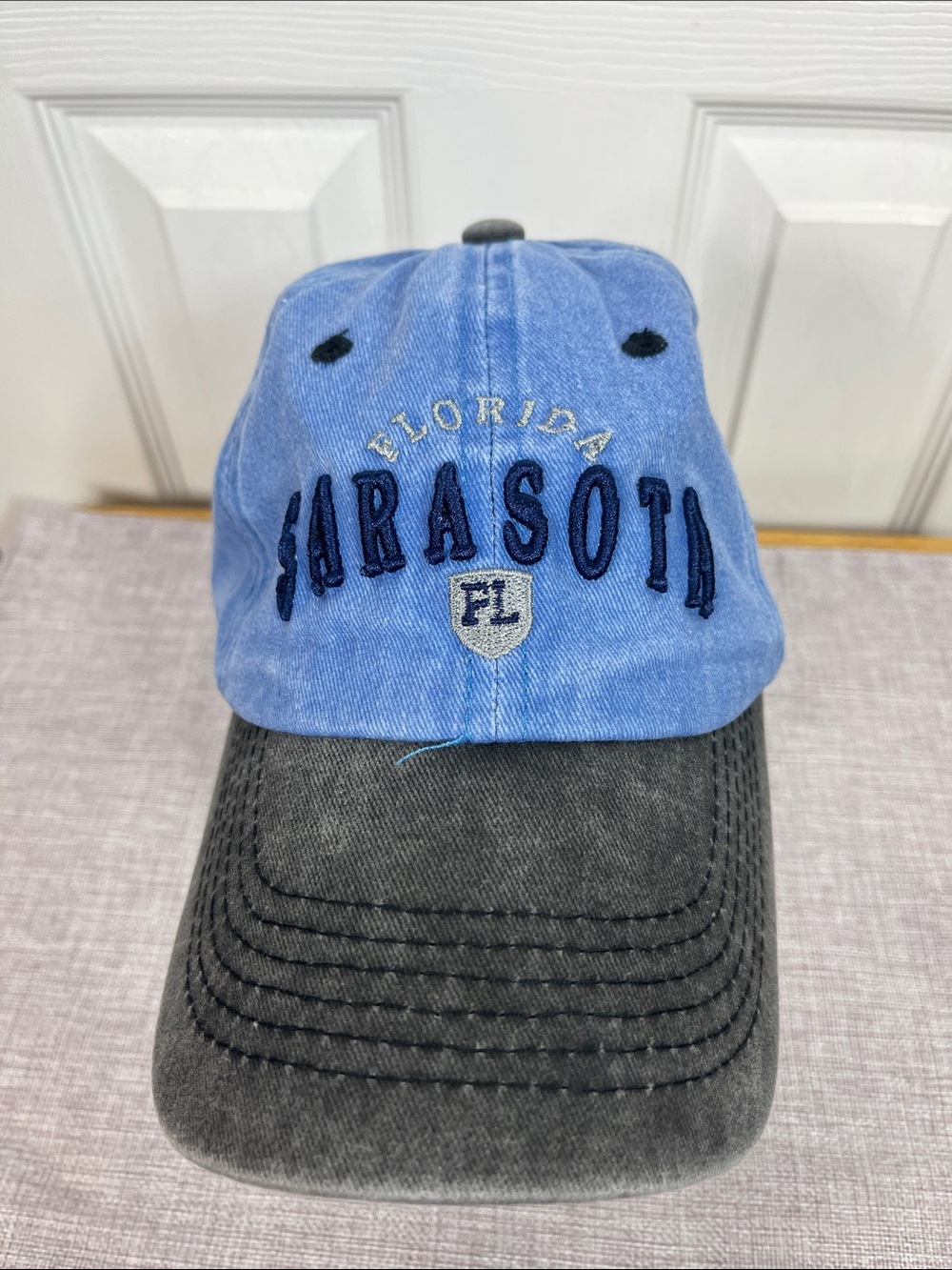 A + I denim looking hat with faded black bill. Adjustable in back. 100% cotton